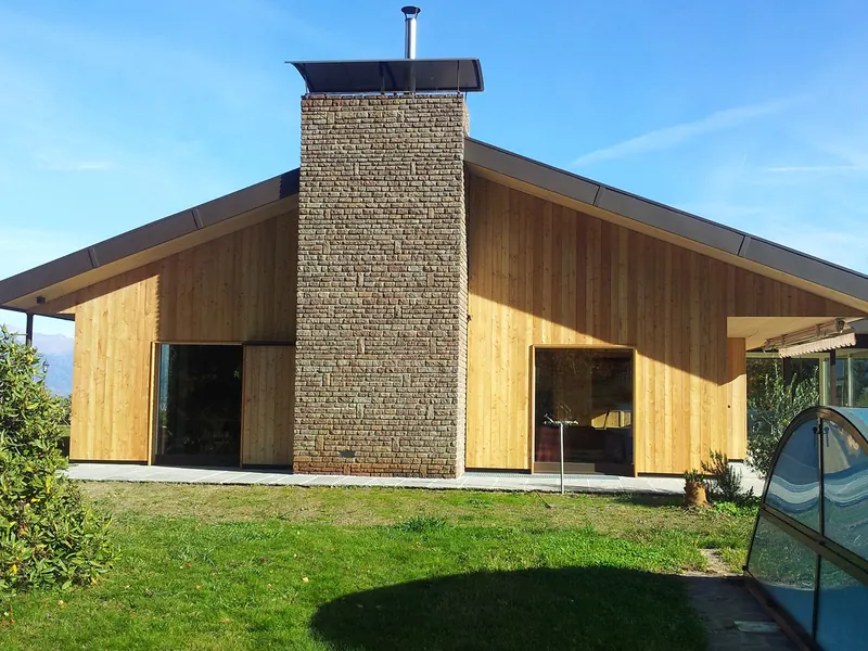Ferienhaus in Holzbauweise mit Lärchenschalung und Steinkamin